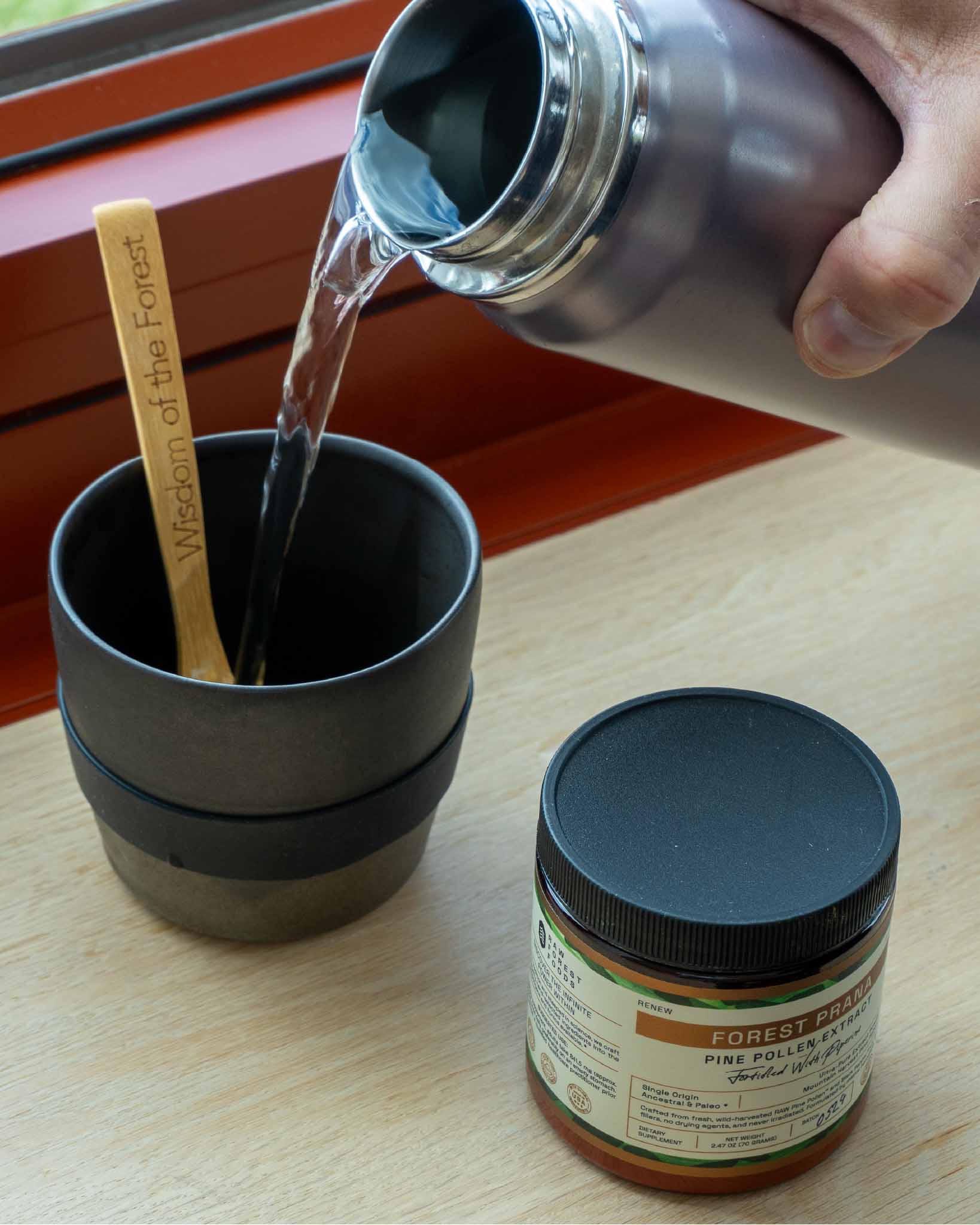 Pouring hot water into a glass before preparing Pine Pollen Extract Powder
