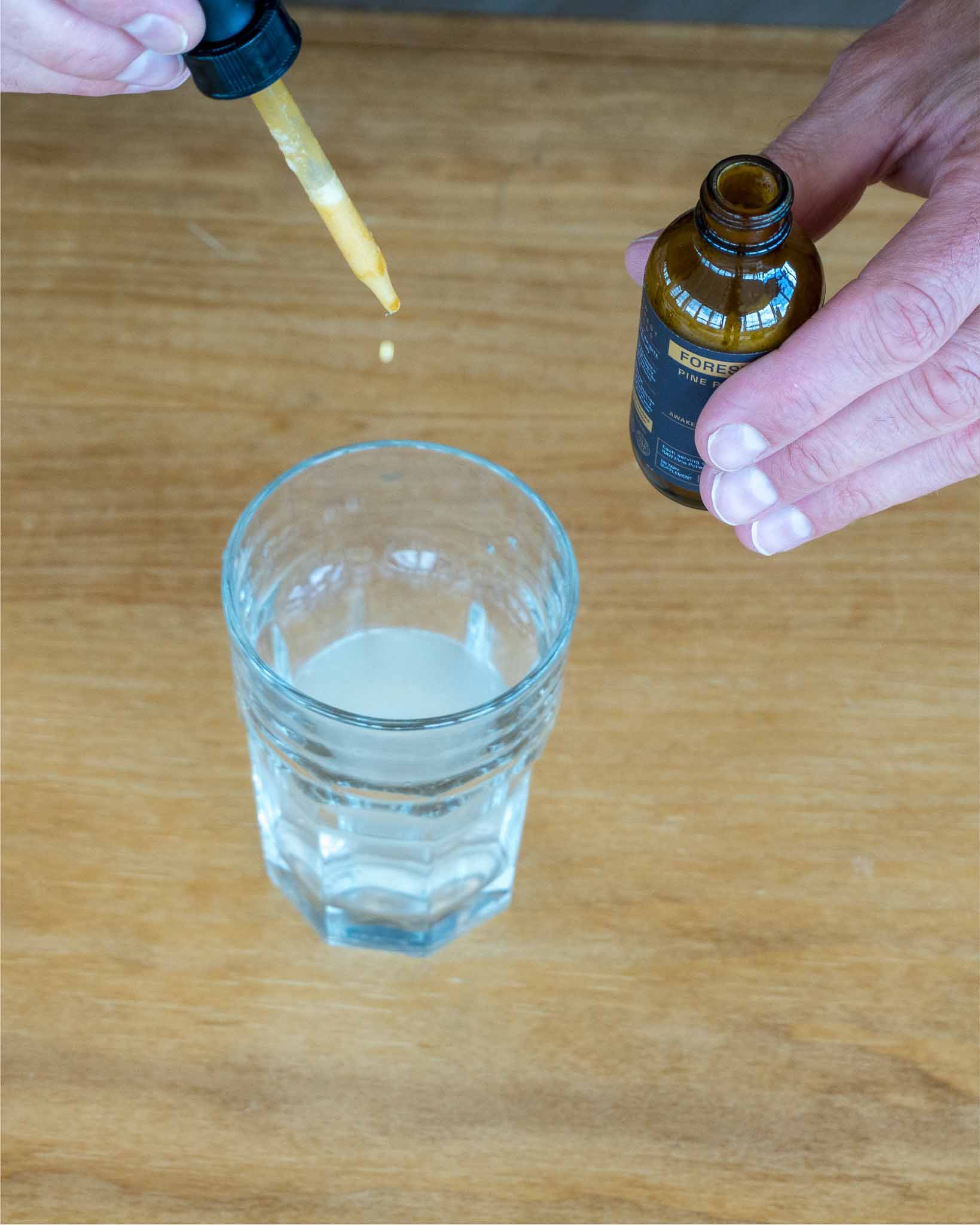 Dispensing a tincture dropper into a glass of water