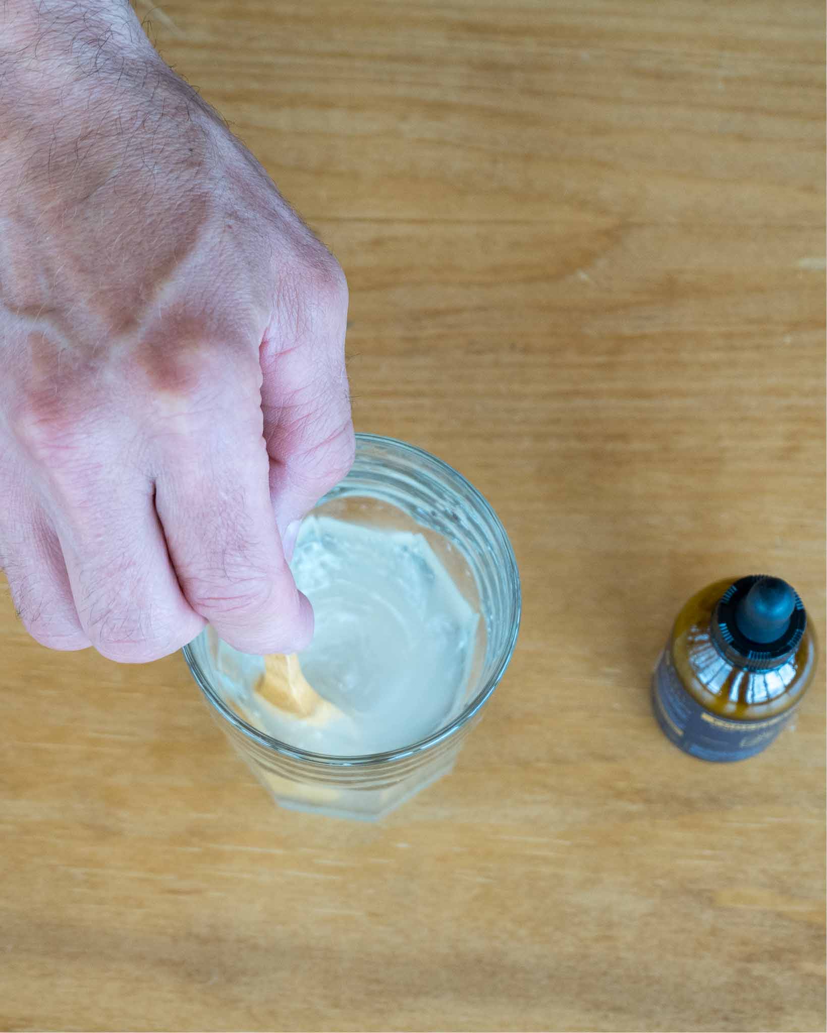 Stirring tincture into a glass of water before drinking